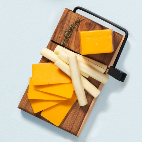 Cheddar and string cheese on a cheese slicer